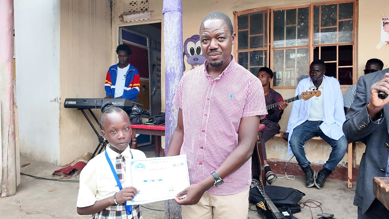 An adult presents a certificate to a learner.