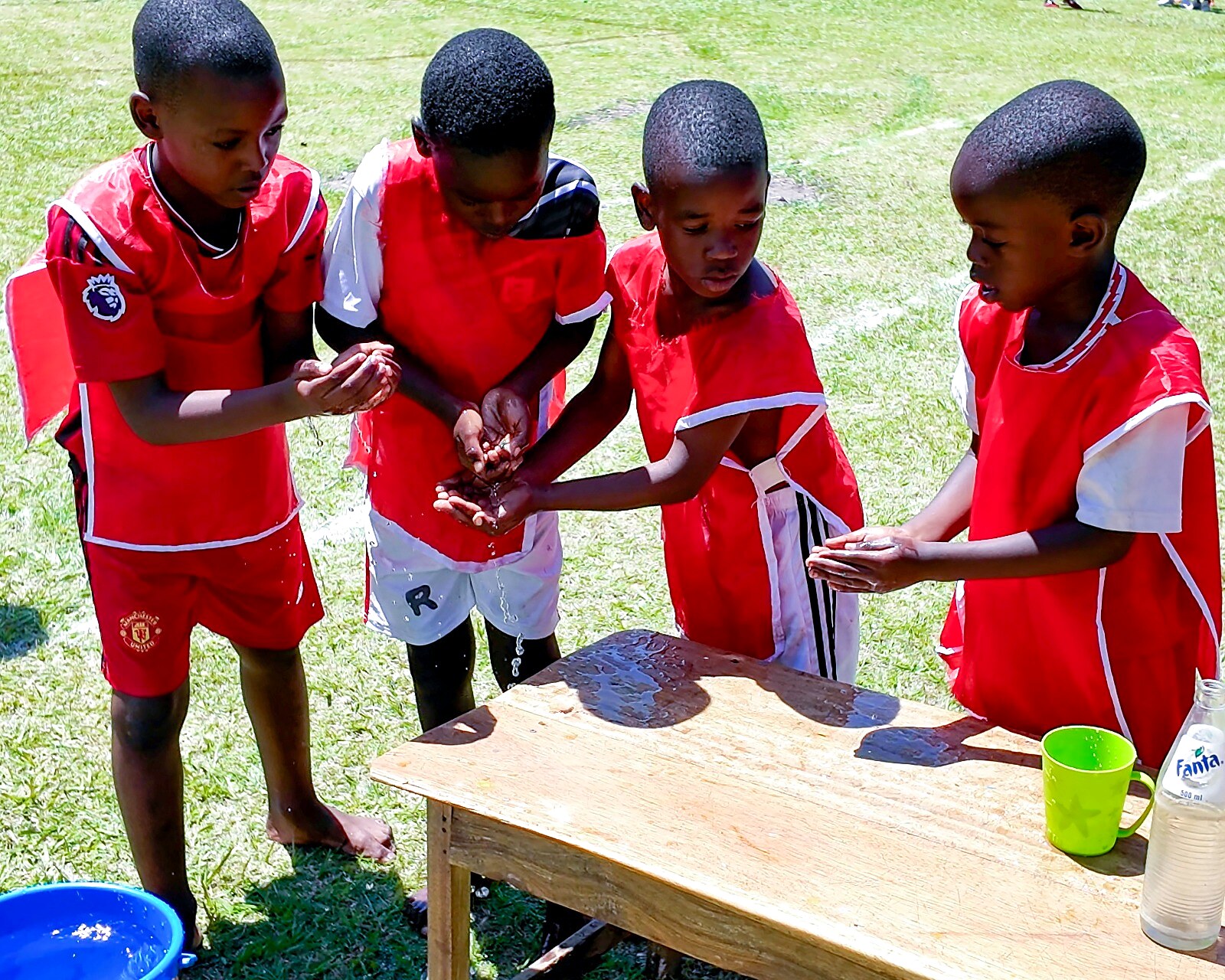 Children collaborate around a table during outdoor play.