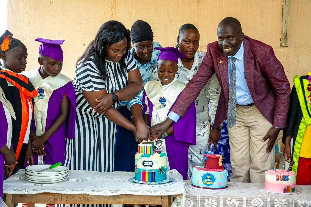 Children and adults gather around a celebration cake.