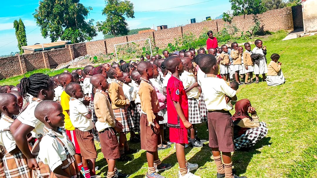 Schoolchildren gather outside during a school event.
